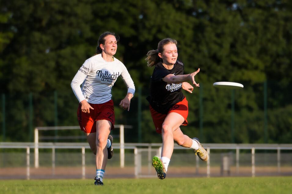 Zwei Mädchen spielen ultimate frisbee auf Wiese