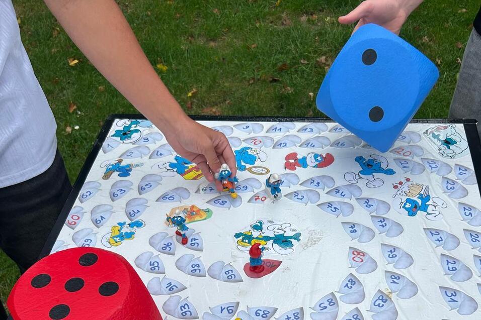 Tisch mit Würfeln und Figuren des Chaosspiels