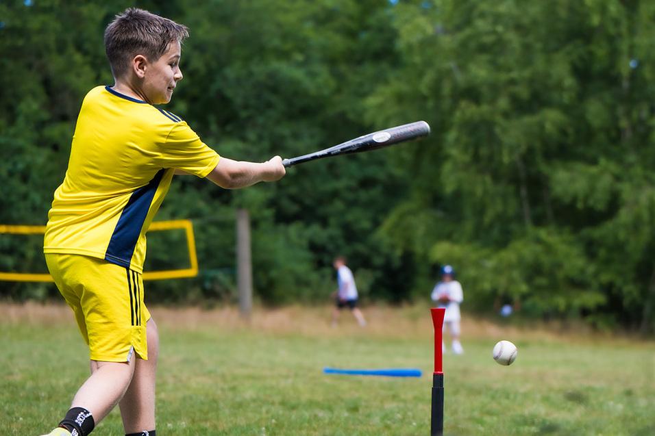 Junge schlägt Baseball
