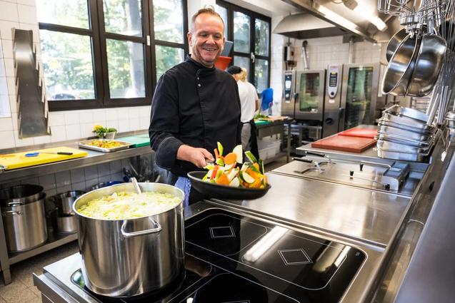 Koch bereitet Essen in einer Pfanne zu