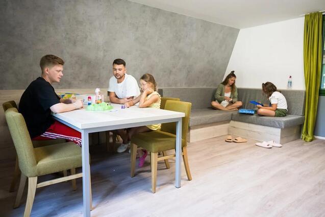 Familie sitzt in Gästehaus im Norddorf