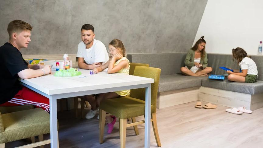 Familie sitzt in Gästehaus im Norddorf