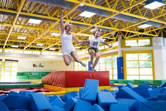 Mutter und Kind springen in Schnitzelgrupe im FlipHop