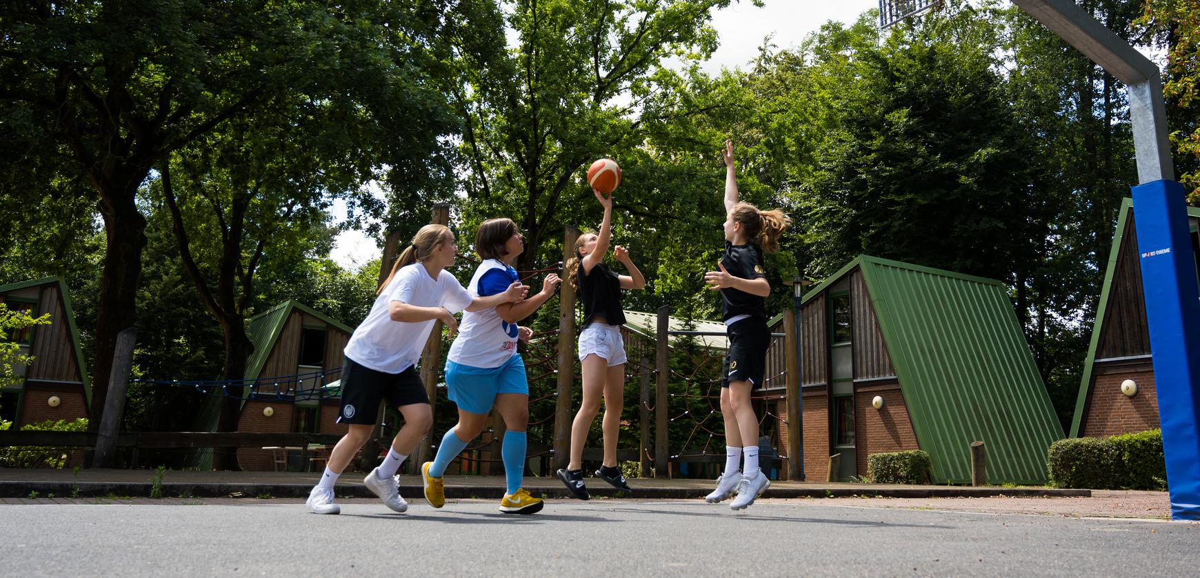 Mädchen spielen outdoor Basketball