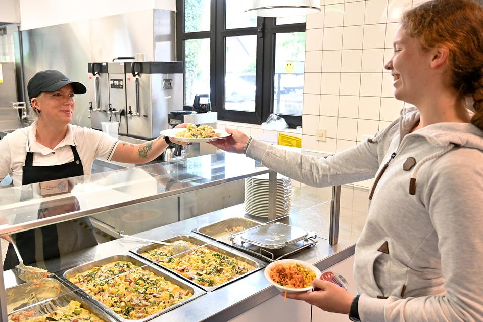 Frau gibt am Buffet Essen an Mädchen aus