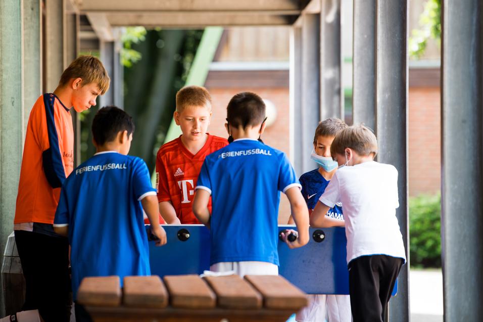 Jungen spielen outdoor am Kicker