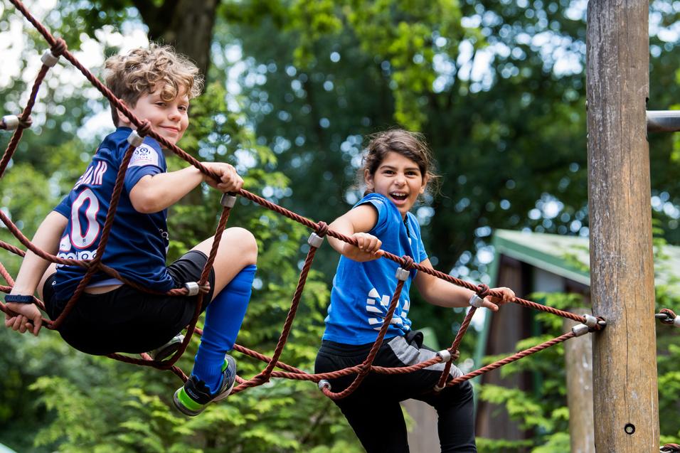 Kinder spielen outdoor auf dem Klettergerüst