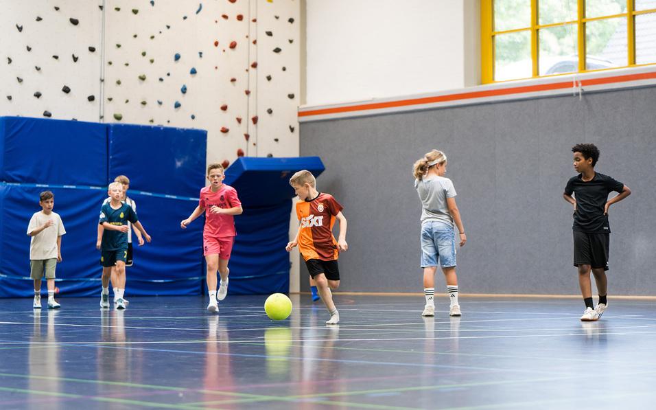 Kinder spielen in der Halle Fußball