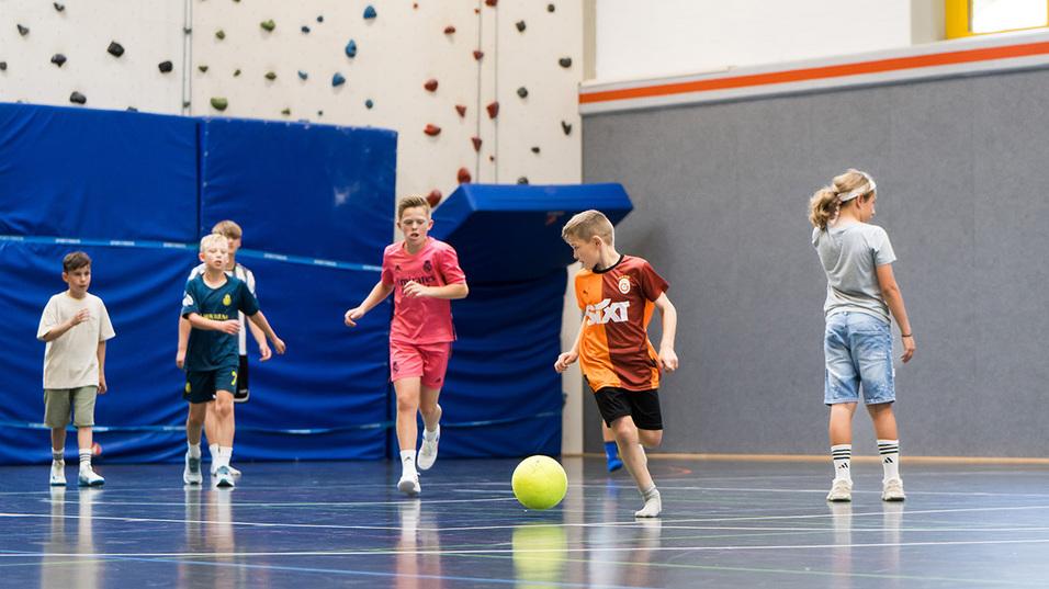Kinder spielen in der Halle Fußball
