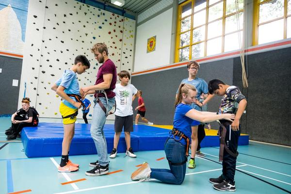 Betreuer bereiten Kinder fürs Klettern vor (Symbolbild Sportangebote)