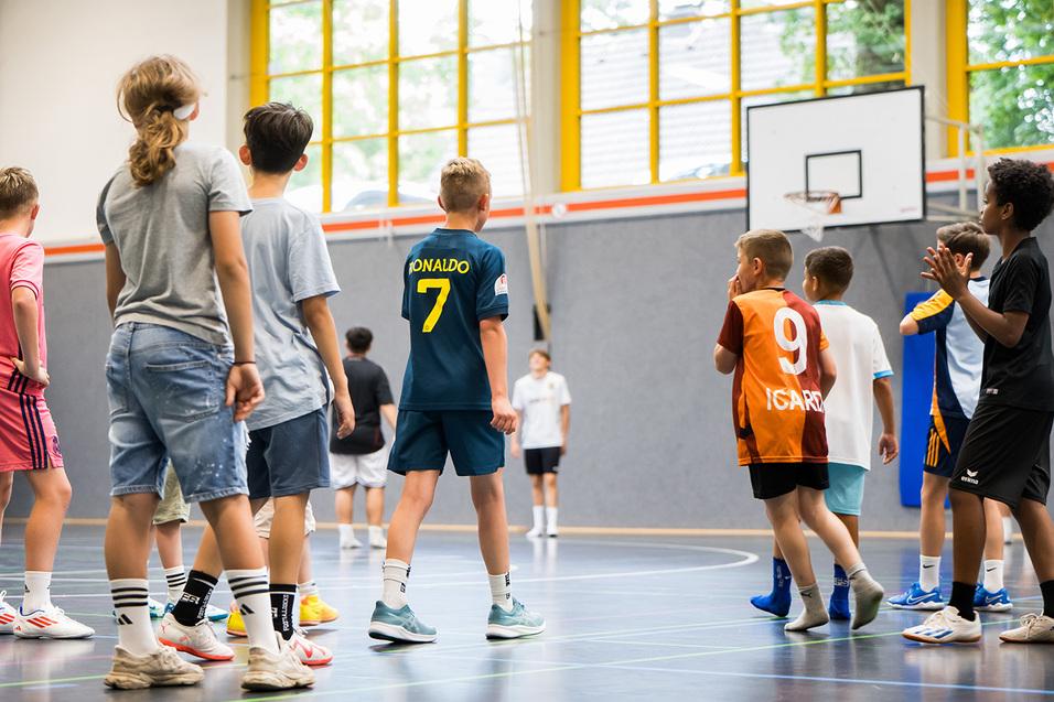 Kinder spielen in der Halle Basketball