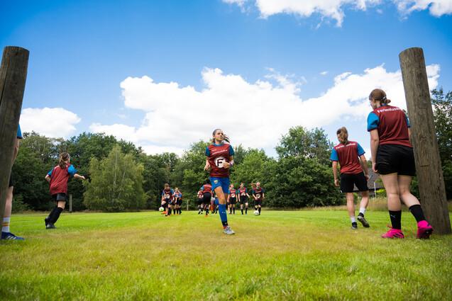 Mädchen spieleoutdoor Fußball auf Bolzwiese