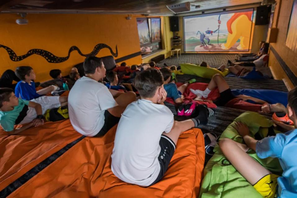 Kinder schauen im Kinoraum einen Flim