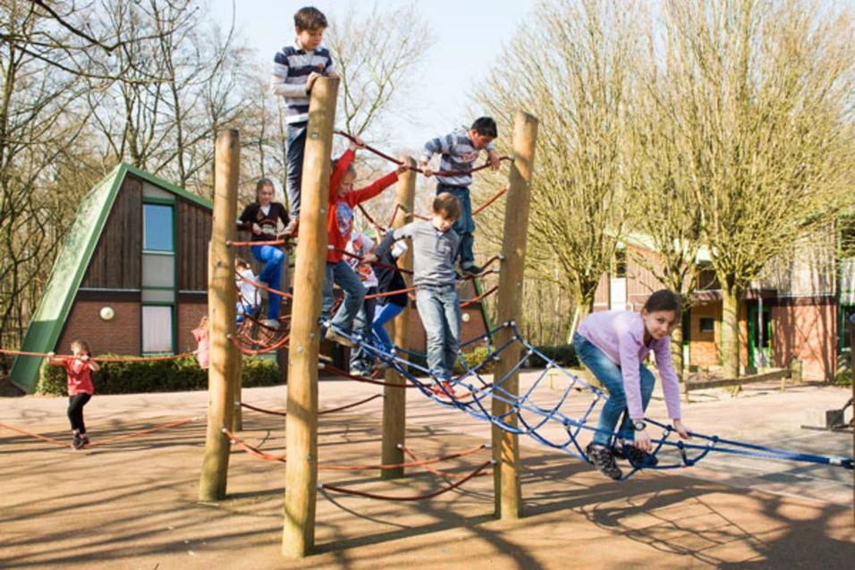 Kinder spielen outdoor auf dem Klettergerüst