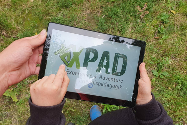 Hände mit iPad draußen: © XPAD Erlebnispädagogik (Niederrhein aktiv)